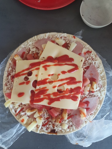 frohen pizza Hawaii with cheese and siracha sauce